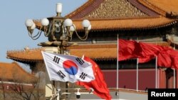 资料图：韩国与中国国旗在北京天安门广场飘扬。（路透社）