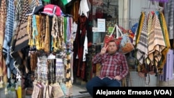 Uno de los pocos vendedores que mantiene abierta su tienda de souvenirs hace el signo de la victoria en una Belén totalmente apagada, el 7 de diciembre de 2023.