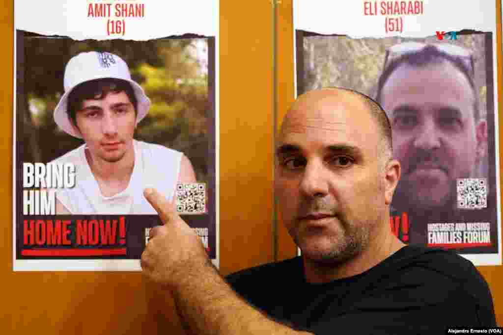 Nir Shani, residente del kibutz Be'eri, posa junto a la foto de su hijo que permanece en Gaza secuestrado por Hamás desde el pasado 7 de octubre. 
