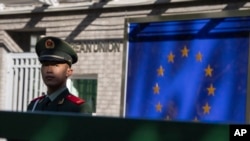 ARCHIVO - Un policía paramilitar chino hace guardia en la entrada del complejo de la Delegación de la Unión Europea en China en Beijing, China, el 14 de octubre de 2023. 
