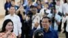 2023 年 7 月 23 日，柬埔寨首相洪森（右）与妻子文·拉尼（左）在柬埔寨金边东南部塔克穆阿的一个投票站投票后，展示了沾有墨水的手指。
