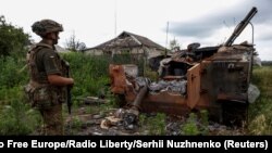 A serviceman of the 68th Oleksa Dovbush Separate Jaeger Brigade stands next to a destroyed Russian BMP-3 infantry fighting vehicle in the newly liberated village of Blahodatne, amid Russia's attack on Ukraine, near the front line in Donetsk Region, Ukraine June 17, 2023.