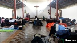 ARCHIVO - Inmigrantes haitianos duermen en una iglesia en Inapari, en la frontera de Perú con Brasil, el 2 de febrero de 2012.