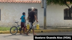 Un hombre lleva gasolina a revendedores de combustible en la calle 43 de Maracaibo, en el estado occidental venezolano de Zulia.