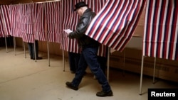 ARCHIVO - Un ciudadano se dispone a depositar su voto durante las elecciones de 2020.