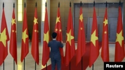 一名男子在越南國會大廈內整理中越兩國國旗準備迎接中國領導人習近平的到訪。 （資料圖片）