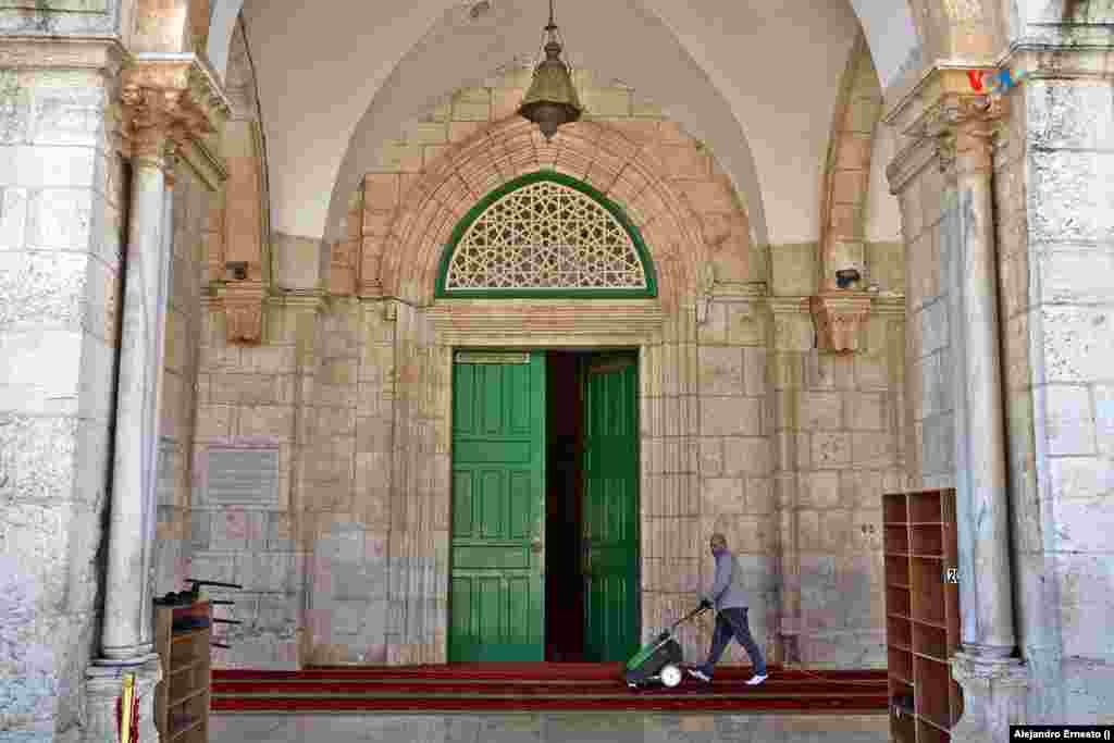 Un hombre limpia las alfombras de la entrada a la mezquita de Al Aqsa, la mayor de Jersusalén.
