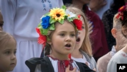 ARCHIVO - Los niños cantan el himno nacional de Ucrania mientras asisten a una ceremonia del primer día de clases en Bucha, Ucrania, el viernes 1 de septiembre de 2023. 