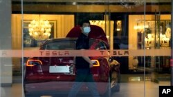A worker walks in a Tesla showroom in Beijing, May 30, 2023.
