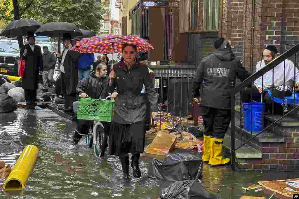 Peatones caminan por una acera inundada, el 29 de septiembre de 2023, en el distrito de Brooklyn en Nueva York, EEUU. 