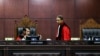 Hakim Mahkamah Konstitusi Anwar Usman (kiri) dan Suhartoyo (kanan) berbincang saat sidang memutus permohonan perubahan syarat pencalonan presiden, di Jakarta, 16 Oktober 2023. (Foto: AFP/MARIANA)
