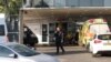 An Israeli policeman talks on the phone outside the emergency entrance to the Sheba Medical Centre in Ramat Gan city on July 15, 2023, after Prime Minister Benjamin Netanyahu was hospitalized.