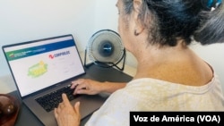 Una usuaria venezolana ingresa sus datos en la página de la empresa estatal venezolana Corpoelec para pagar su mensualidad de servicio eléctrico, en la ciudad de Maracaibo.