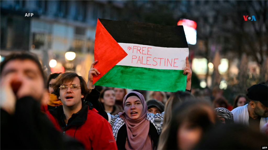 Una mujer sostiene la bandera palestina que tiene escrito: "Palestina libre", durante una manifestación en apoyo del pueblo palestino en Belgrado, capital de Serbia.