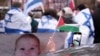 Seseorang mengibarkan bendera Palestina di luar Mahkamah Internasional di Den Haag, Belanda, 12 Januari 2024. (Foto: AP)