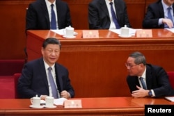 资料照：中国领导人习近平与总理李强在北京人大会堂出席全国政协会议开幕式时交谈。（2024年3月4日）