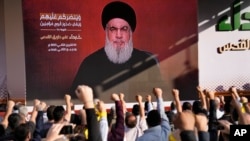 ក្រុម​អ្នក​គាំទ្រ​​ក្រុម Hezbollah ដែល​គាំទ្រ​ដោយ​អ៊ីរ៉ង់ លើក​ដៃ​ឡើង​ដើម្បី​បង្ហាញ​ការ​គាំទ្រ​​ចំពោះ​មេដឹកនាំ​របស់​ខ្លួនគឺ​លោក Hassan Nasrallah ដែល​បាន​បង្ហាញ​ខ្លួន​​នៅ​ក្នុង​វីដេអូ​មួយ​ក្នុង​អំឡុងពេល​ជួបជុំ​គ្នា​ក្នុង​ទីក្រុងបេរូត ប្រទេស​លីបង់ កាល​ពី​ថ្ងៃ​សុក្រ។