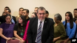 President-elect Bernardo Arevalo, center, gives a press conference in Guatemala City, Guatemala, Dec. 8, 2023. Prosecutors in Guatemala asked a court Friday to strip the president-elect of his immunity. 