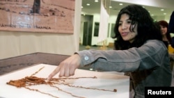 ARCHIVO - Un asistente de arqueología muestra un quipu antes de la inauguración de una exposición en el Museo Nacional de Lima. 