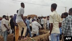 Mourners gather to bury the victims killed by an artillery shell strike in southern Khartoum, Sudan, on June 11, 2023.