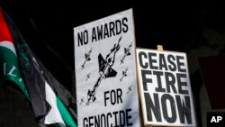 Para demonstran membawa poster yang berisi seruan untuk gencatan senjata di Gaza dalam aksi protes di Hollywood di dekat area tempat perhelatan Oscar ke-96 digelar di Los Angeles, pada 10 Maret 2024. (Foto: AP/Etienne Laurent)