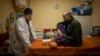 El médico ucraniano Yurii Kuznetsov habla con la víctima de las minas terrestres Oleksandr Kolisnyk en el hospital de Izium, Ucrania, el domingo 19 de febrero de 2023. (Foto AP/Vadim Ghirda, Archivo)