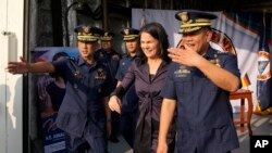 正在马尼拉访问的德国外交部长安娜莱娜·贝尔伯克（中）与菲律宾海岸警卫队发言人阿曼多·巴利洛少将（左）和菲律宾海岸警卫队司令罗尼·吉尔·加万上将（右）登上菲律宾海上巡逻舰“加布里埃拉·思朗”号。（2024年1月11日）