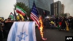 Protesters burn Israeli and U.S. flags during a rally outside the former U.S. embassy in Tehran, Iran, Nov. 4, 2023.