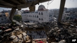 Palestinians look at a damaged residential building after an Israeli strike in Rafah, southern Gaza Strip, Jan. 10, 2024. 