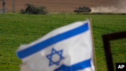 Un tanque israelí se mueve cerca de la frontera entre Israel y Gaza visto desde el sur de Israel, el 6 de marzo de 2024.