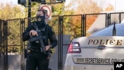 Un oficial del Servicio Secreto de EEUU toma posición en la calle cuando la caravana del presidente Donald Trump llega a la Casa Blanca después de jugar golf en su Trump National Golf Club en Sterling, Virginia, en Washington, el 8 de noviembre de 2020.
