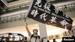 资料照片：一名示威者手持旗帜参加在香港的抗议活动。(2020年6月12日)