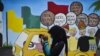 FILE - Seorang pemuda menggunakan ponselnya di depan mural kampanye Pemilu 2019, Banda Aceh, 17 Maret 2019. (Foto: AFP/CHAIDEER MAHYUDDIN)