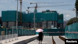 一名女子走过北京的一处住宅楼建筑工地。（2022年7月15日）