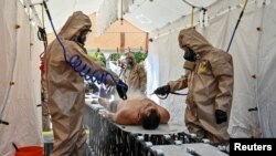 FILE - Members of the State Emergency Service attend nuclear disaster response drills amid shelling around the Zaporizhzhia Nuclear Power Plant, in Ukraine, Aug. 17, 2022.