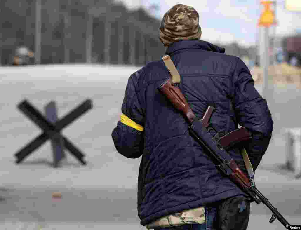 Припадник на Територијалните одбранбени сили на Украина чува стража на контролен пункт на периферијата на Киев, Украина, 27 февруари 2022 година (Ројтерс/Михаил Палинчак)