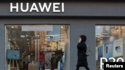 资料照：一名女子走过乌克兰首都基辅市中心的一家华为商店。（2019年11月11日）