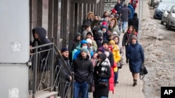Para warga di St. Petersburg, Rusia, tampak mengantre untuk mengambil dolar AS dan Euros di sebuah ATM, pada 25 Februari 2022. (Foto: AP/Dmitri Lovetsky)