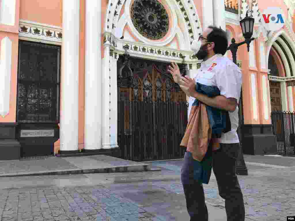 Leandro Rossi, guía y editor principal del proyecto Reencontrarte Caracas, relata anécdotas relacionadas con la construcción de la Basílica de Santa Capilla en el casco central de Caracas, durante recorrido en febrero de 2022. Foto: Carolina Alcalde - VOA. 