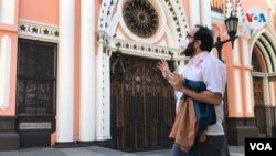 Leandro Rossi, guía y editor principal del proyecto Reencontrarte Caracas, relata anécdotas relacionadas con la construcción de la Basílica de Santa Capilla en el casco central de Caracas durante recorrido. Foto: Carolina Alcalde - VOA. 
