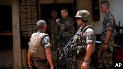 French soldiers search a house used as an armed cache in the Christian sector of PK12, the last checkpoint at the exit of the town, Bangui, Central African Republic, Feb. 11, 2014.