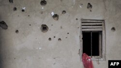 FILE - The wall of a house riddled with bullets is seen in Nzenga, which has been repeatedly attacked by the armed group Allied Democratic Forces (ADF), Beni territory, northeastern Democratic Republic of Congo, May 24, 2021.