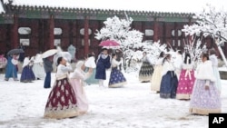 Para pengunjung menikmati salju di Istana Gyeongbok di Seoul, salah satu dari tempat populer di Korea Selatan, Rabu, 27 November 2024. (Foto: Lee Jin-man/AP Photo)