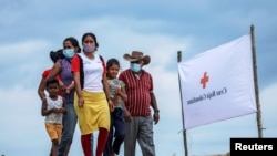 Refugiados venezolanos caminan en dirección a un refugio temporal en el que esperan recibir atención médica, en Arauquita, Colombia, el 28 de marzo de 2021.