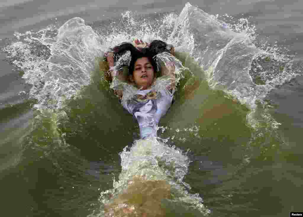A girl cools off in the waters of the Ganges River during a hot summer morning in Allahabad where the temperature was expected to reach 46 degree Celsius, India, May 31, 2015. 