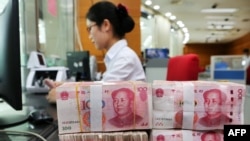 中國江蘇省南通市的一家銀行的一名員工處理100元紙幣。資料圖片，2018年7月23日。