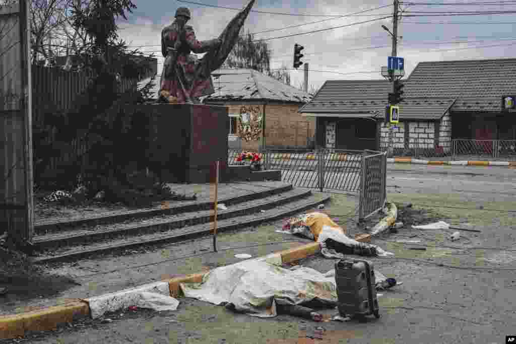 The dead bodies of people killed by Russian shelling lay covered in the street in the town of Irpin, March 6, 2022.