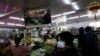 FILE - People shop for vegetables at a market in Beijing, Jan. 15, 2021.