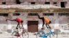 Somali boys perform tricks on their bicycles near a ruined building in Hamarweyne district of Mogadishu, Jan. 25, 2021. With poor roads and equipment, Somalia's cycling federation faces an uphill battle to prepare for upcoming international competition.