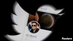 FILE - Elon Musk's Twitter account is seen through a Twitter logo in this illustration made April 25, 2022.